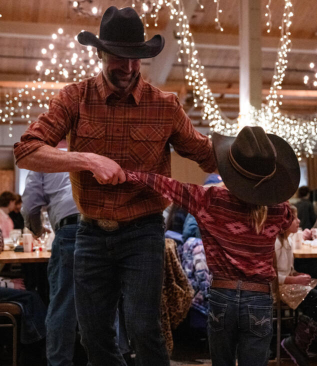 A father and young son dance together during a Western BBQ at Steamboat Resort's Thunderhead Lodge. A father and young son dance together during a Western BBQ at Steamboat Resort's Thunderhead Lodge.